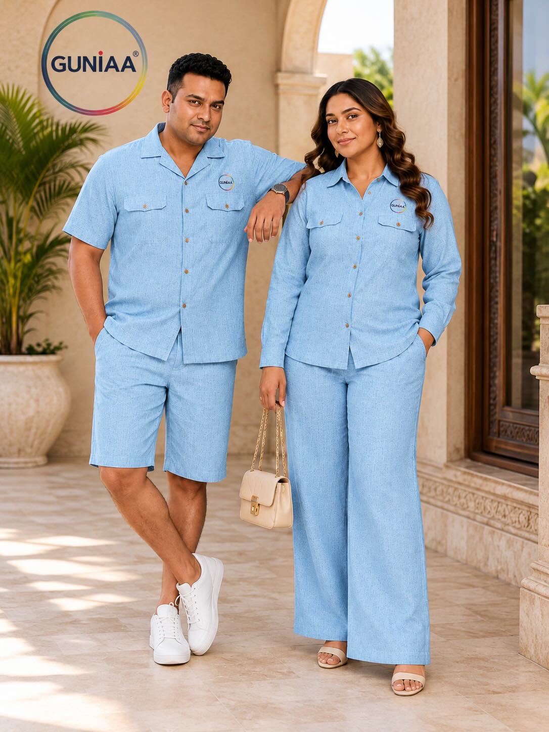 A man and a woman modeling matching light blue short-sleeve button-up pajama sets in an outdoor patio setting. The brand logo 'GUNIAA' is visible in the top left corner.